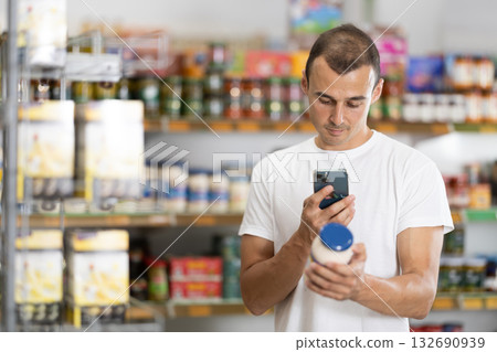 Male buyer scan QR code on jar of mayonnaise Male buyer scan QR code on jar of mayonnaise 132690939