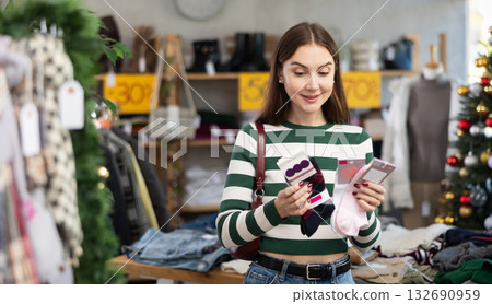 Woman client looks at products in store, choose closely socks 132690959