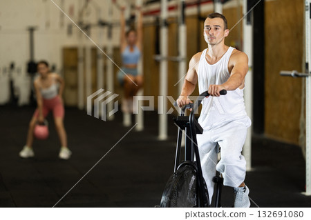 Young man exercising on exercise bike in gym 132691080