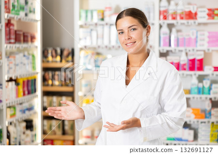 Young female pharmacist welcoming clients in chemist's shop 132691127
