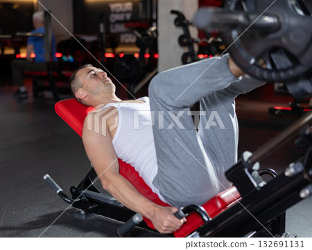 Young man training his legs with barbell Young man training his legs with barbell 132691131