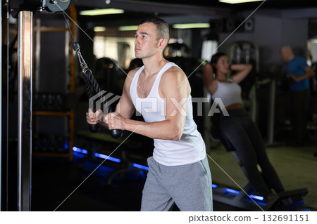 Man in sportswear training on rope loop simulator Man in sportswear training on rope loop simulator 132691151
