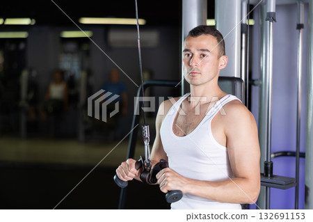 Man in sportswear training on rope loop simulator Man in sportswear training on rope loop simulator 132691153
