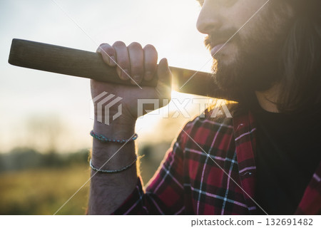 lumberjack holding axe at sunset 132691482