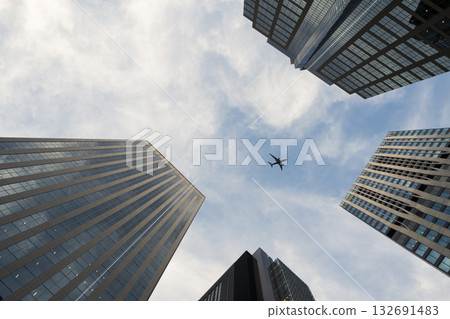 Airplane Flying Overhead Between Skyscrapers Airplane Flying Overhead Between Skyscrapers 132691483