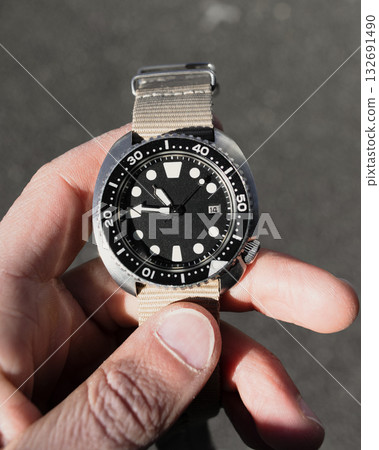 Close-Up of Hand Holding Black Diver Watch Close-Up of Hand Holding Black Diver Watch 132691490