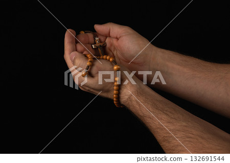 Hands holding wooden rosary beads during prayer in quiet reflection Hands holding wooden rosary beads during prayer in quiet reflection 132691544