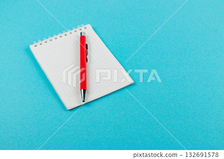Notepad and pen on a blue surface for writing notes Notepad and pen on a blue surface for writing notes 132691578