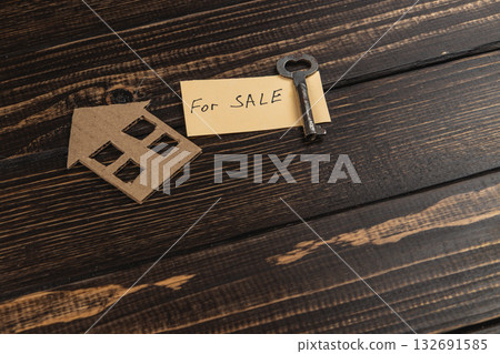 House key and sale sign on wooden table representing real estate listing House key and sale sign on wooden table representing real estate listing 132691585