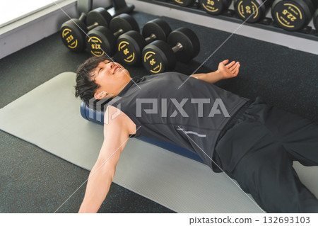 一名身穿運動服的男子正在使用健身桿進行伸展運動。 一名身穿運動服的男子正在使用健身桿進行伸展運動。 132693103