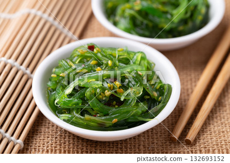 Wakame seaweed salad with sesame seed in a bowl with chopsticks Wakame seaweed salad with sesame seed in a bowl with chopsticks 132693152