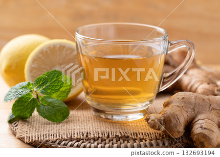 Lemon and ginger tea in cup glass with mint leaf, Healthy hot drink 132693194