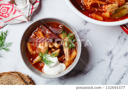 Classic homemade borscht with chicken in a grey bowl. Classic homemade borscht with chicken in a grey bowl. 132693377