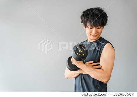 亞洲年輕男子在健身房用啞鈴進行肌肉訓練 亞洲年輕男子在健身房用啞鈴進行肌肉訓練 132693507