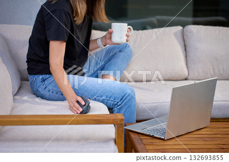 Woman working with laptop and coffee on terrace sofa 132693855