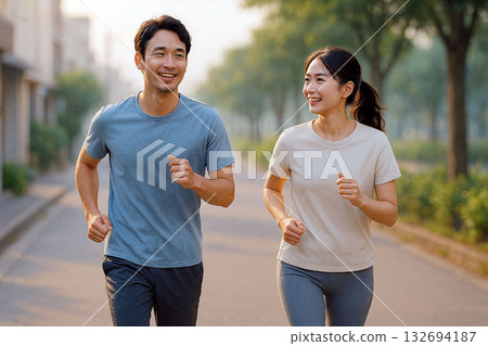 一對健康的日本夫婦在清晨一起慢跑。 一對健康的日本夫婦在清晨一起慢跑。 132694187