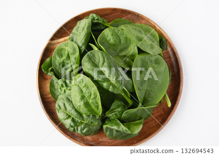 Baby spinach on a wooden plate 132694543