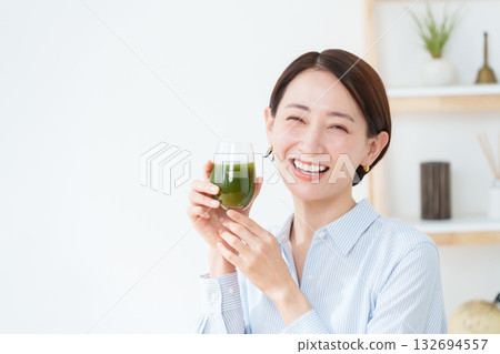 A woman drinking green juice A woman drinking green juice 132694557