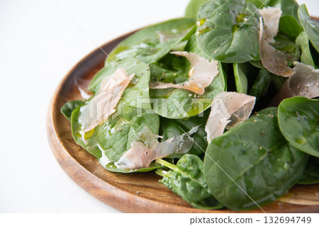 Baby spinach salad on a wooden plate Baby spinach salad on a wooden plate 132694749
