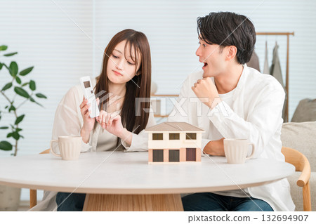 一對年輕夫婦正在考慮蓋房子預算(預算超支、物價上漲、房價高企) 一對年輕夫婦正在考慮蓋房子預算(預算超支、物價上漲、房價高企) 132694907
