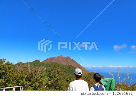 一個男孩站在妙劍嶽山頂的觀景台上眺望遠方。 一個男孩站在妙劍嶽山頂的觀景台上眺望遠方。 132695652