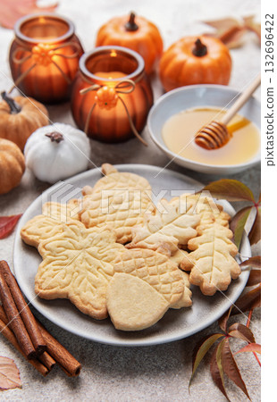 Autumn cookies, candles, pumpkins, honey, and cinnamon decorating table Autumn cookies, candles, pumpkins, honey, and cinnamon decorating table 132696422