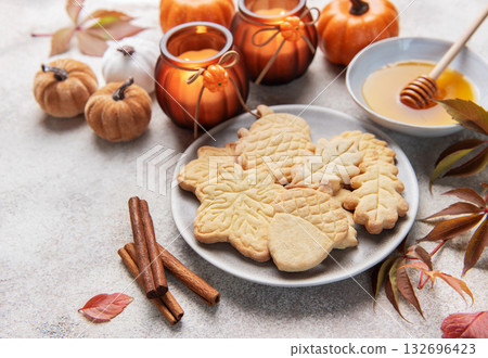 Autumn cookies, candles, pumpkins, honey, and cinnamon decorating table Autumn cookies, candles, pumpkins, honey, and cinnamon decorating table 132696423