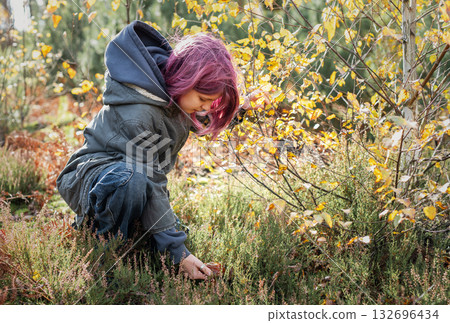 Girl with pink hair foraging mushrooms in autumn forest Girl with pink hair foraging mushrooms in autumn forest 132696434