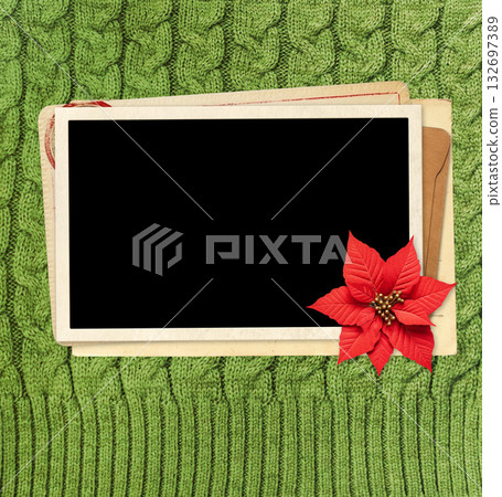 Christmas background with poinsettia, retro photo, vintage envelope, cards on wool sweater texture of green color. Nostalgic scrapbooking mockup template. Winter holiday backdrop. Copy space for text Christmas background with poinsettia, retro photo, vintage envelope, cards on wool sweater texture of green color. Nostalgic scrapbooking mockup template. Winter holiday backdrop. Copy space for text 132697389