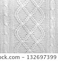 Wool sweater texture of white color with cable knitting stitch pattern. Natural knitted wool white material with ornament. Horizontal or vertical background with handmade knitted fabric texture 132697399