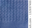 Wool sweater texture of blue color with cable knitting stitch pattern. Natural knitted wool dark blue color material with ornament. Horizontal or vertical background with handmade knitted fabric 132697400