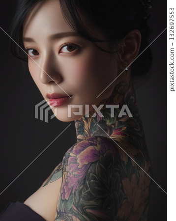 Elegant Korean woman with intricate tattoos posing in a dark setting at a studio 132697553