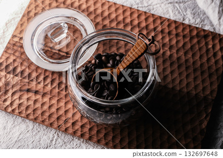 Coffee beans in a glass jar with a wooden spoon 132697648