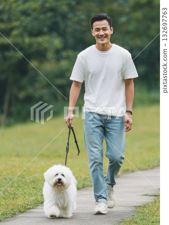 Asian man walking happy dog in park 132697763