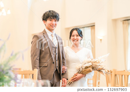 A bride and groom entering a chapel, wedding hall, and virgin road with a bouquet at a wedding ceremony A bride and groom entering a chapel, wedding hall, and virgin road with a bouquet at a wedding ceremony 132697903