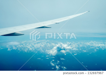 Airplane wing flying above the clouds during daylight flight Airplane wing flying above the clouds during daylight flight 132697967