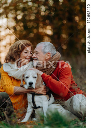 Senior couple walking dog in autumn forest. Senior couple walking dog in autumn forest. 132698430