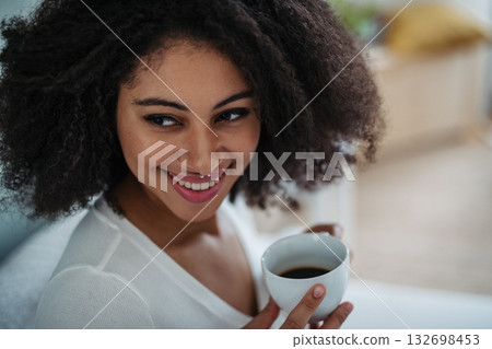 Close-up portrait of laughing young woman indoors, looking at camera. 132698453