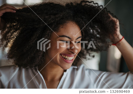 Close-up portrait of beautiful young woman with curly hair. Close-up portrait of beautiful young woman with curly hair. 132698469