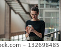 Portrait of young businesswoman reading email on smartphone. 132698485