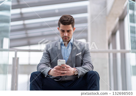 Young businessman making browsing on smartphone in an office. Young businessman making browsing on smartphone in an office. 132698503