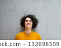Portrait of beautiful woman with curly hair, gray bacground. 132698509