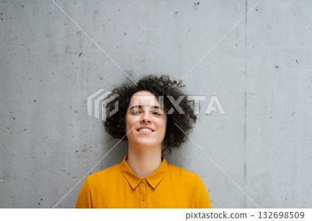 Portrait of beautiful woman with curly hair, gray bacground. 132698509