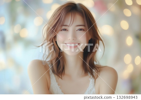 A portrait of a young woman with a cute smile. The background is a glittering bokeh of lights. 132698943