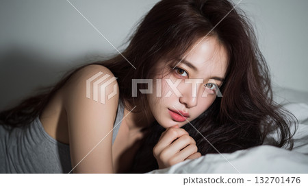Candid portrait of a korean woman in soft lighting relaxing on a bed at night Candid portrait of a korean woman in soft lighting relaxing on a bed at night 132701476