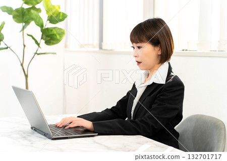 女僱員使用一台筆記本電腦 132701717