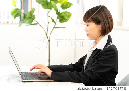 Female employee working with a laptop Female employee working with a laptop 132701718
