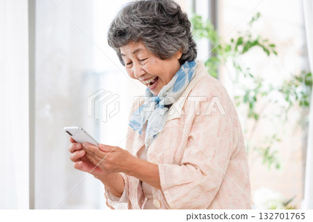 Senior woman operating a smartphone 132701765
