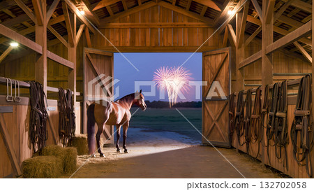 A horse watches fireworks through the open gates of a wooden stable at dusk. 132702058