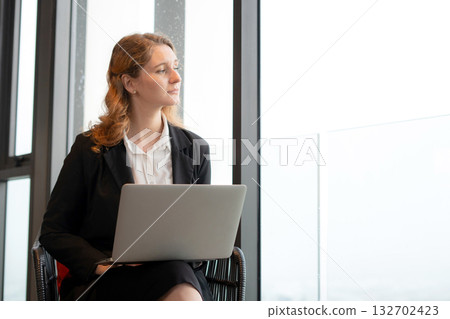 Happy caucasian businesswoman working on laptop in comfortable modern office. 132702423